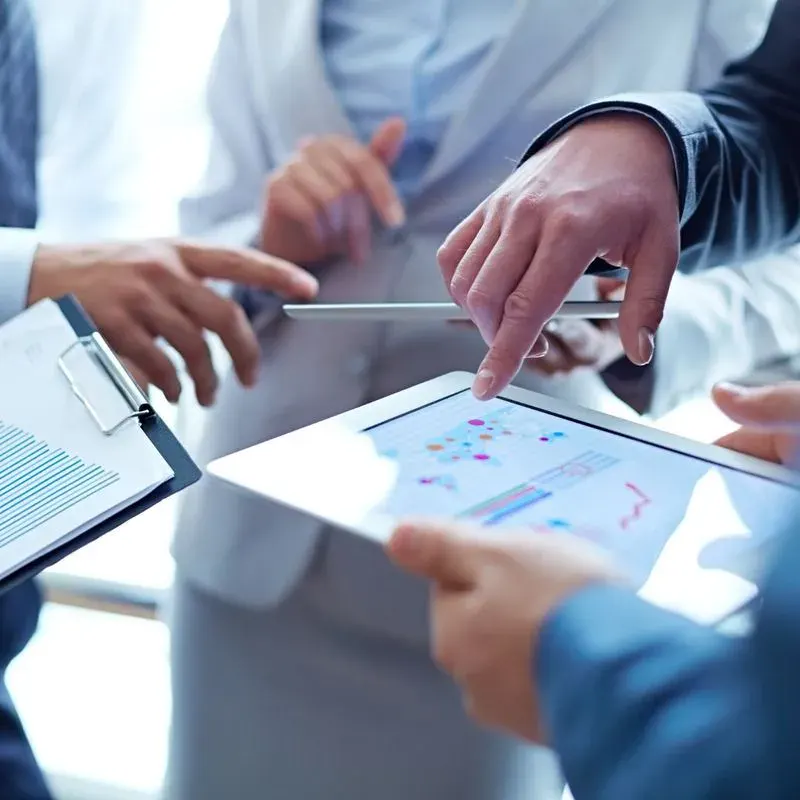 Profissionais analisando indicadores em um tablet durante um atendimento